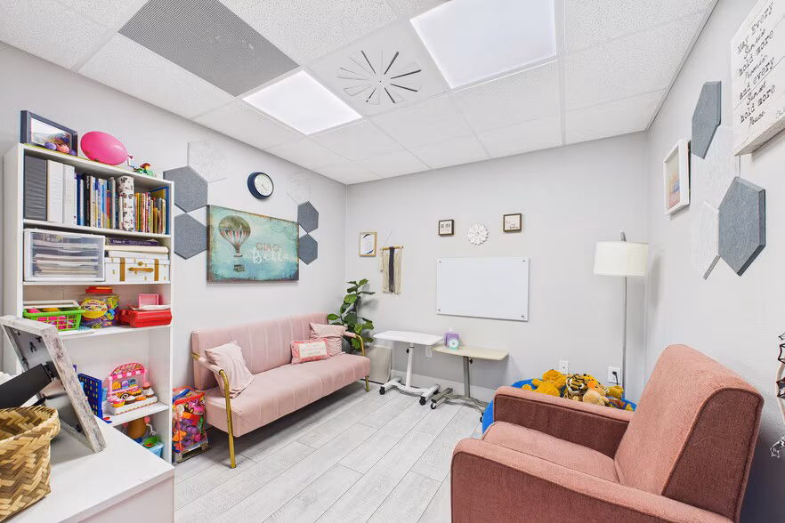 Furnished therapy office suite with seating and natural light